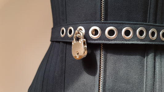 Close-up of a padlocked waist strap on a corset