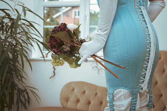 Man wears a baby blue thigh length corset dress