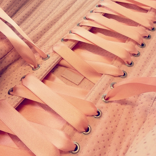 Close-up on lacing on a pink spot coutil corset