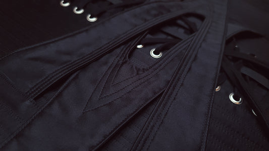 Close up of interlocking waist straps in black silk satin.