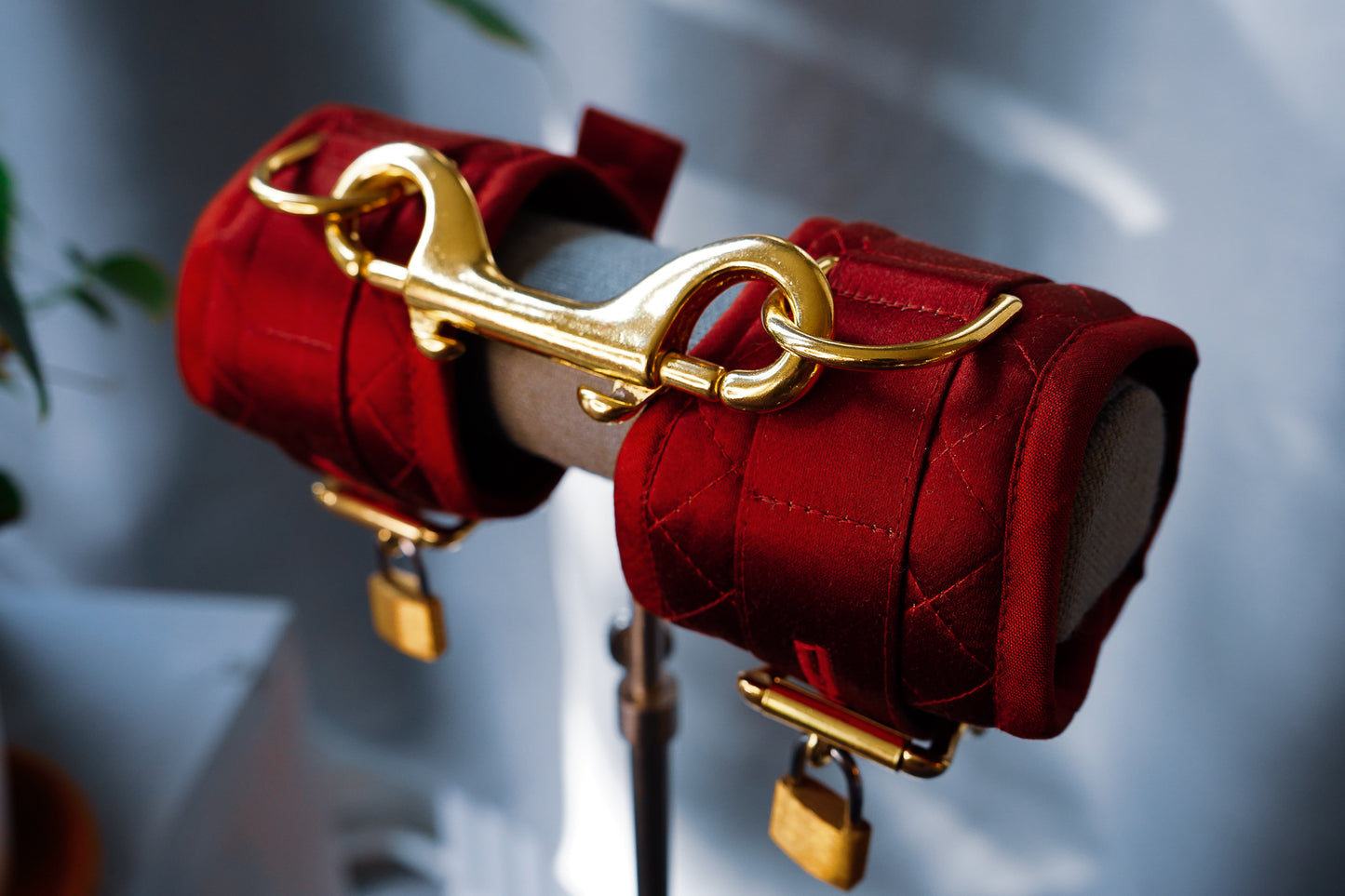 Close up of the Morgan cuffs in red silk satin with gold hardware