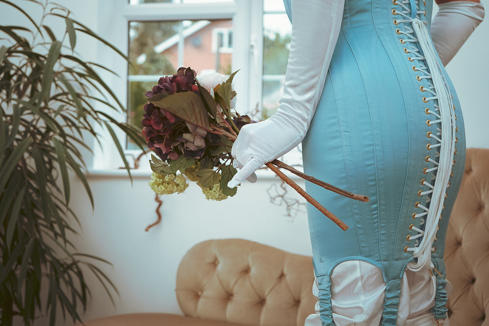 A model wears a thigh length baby blue corset dress