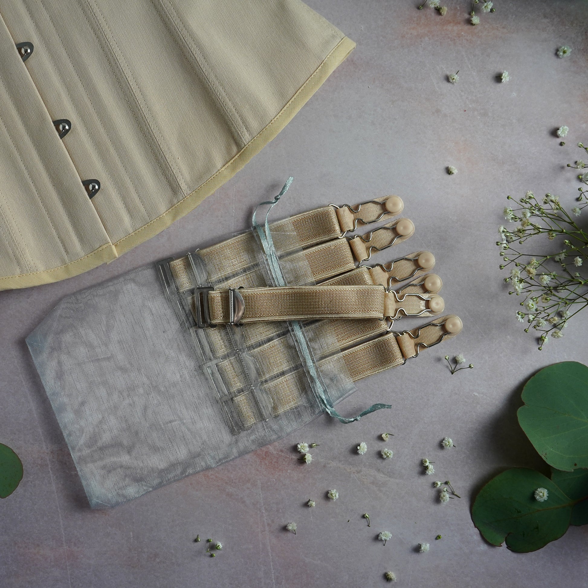 A set of 6 beige suspenders with a matching corset