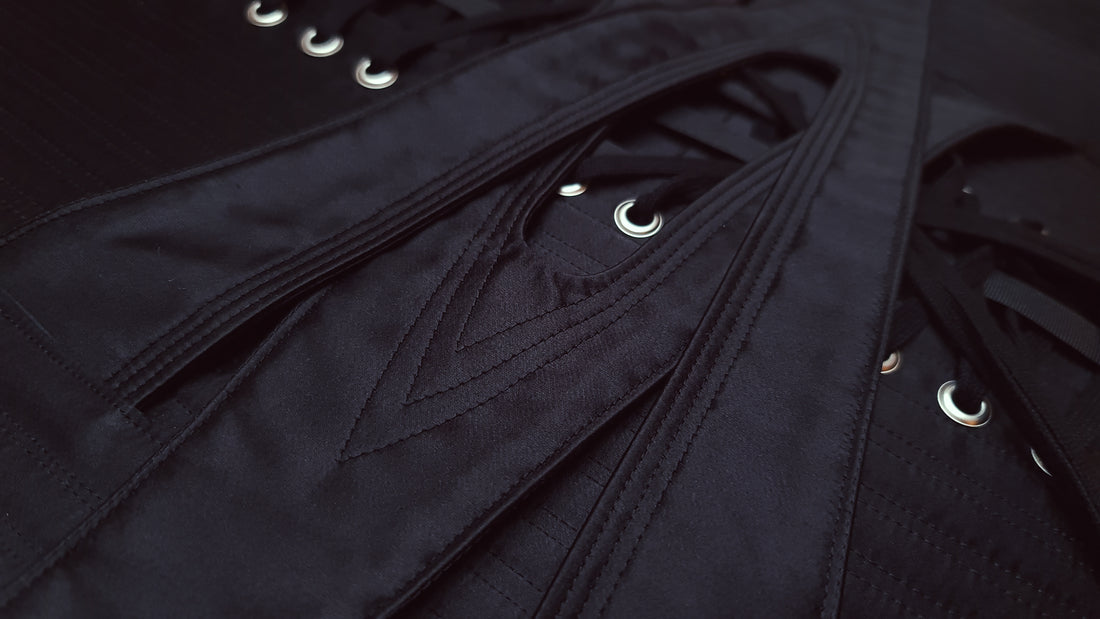 Close up of interlocking waist straps in black silk satin.