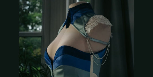 Close up of a posture capelet in blue silk with ivory lace and pearl detail.