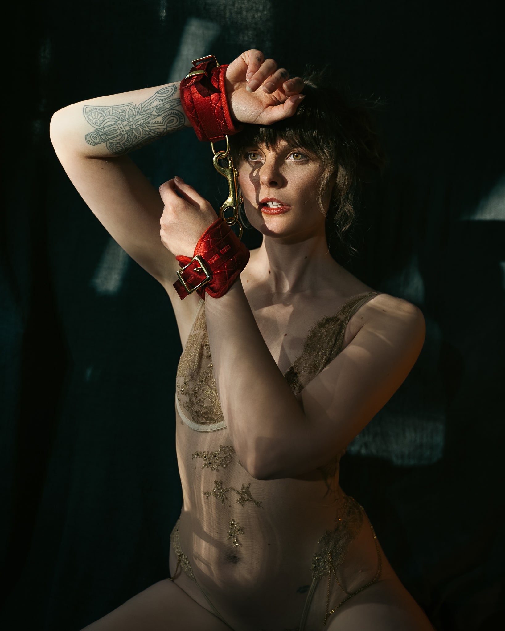 Model wears the red Morgan wrist cuffs with gold lingerie