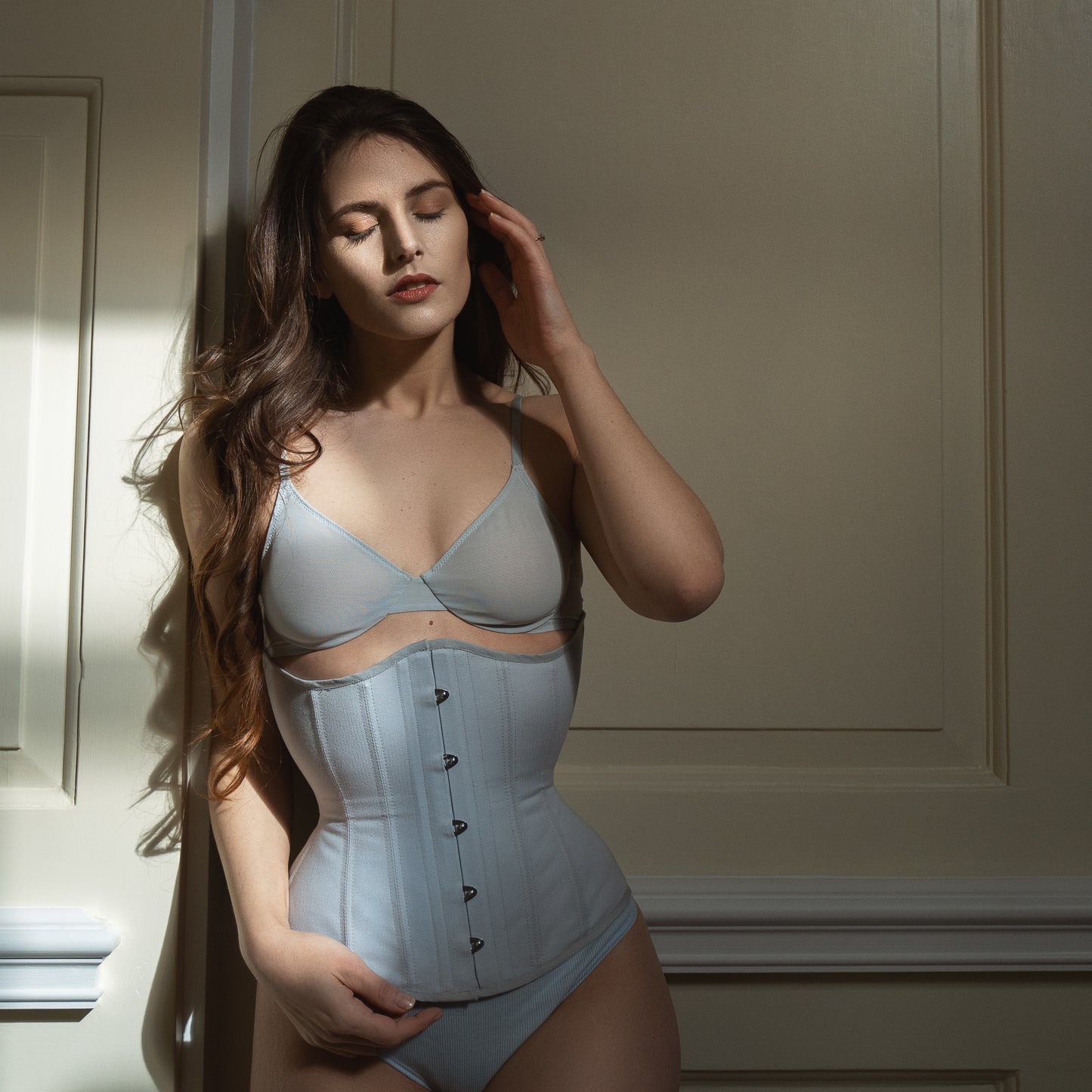 Model wears a blue- grey Heledd stealth corset with matching lingerie