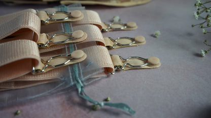 Close-up of beige suspenders